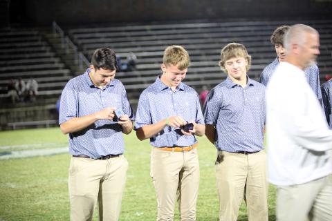 Golfers Nolan Henderson (left) and Madden Drake (right) get their first glimpse of their state championship ring during the ring ceremony for winning the boys Class A Division 1 state championship. (Photo by Bo Underwood)