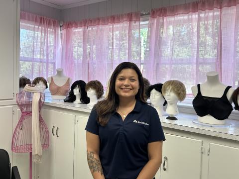  Jenny Jenkins, founder of Jenny's Boutique poses in front of some of the boutique's wig selection. (Photo by Mark Wells)