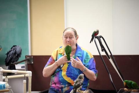 One of the many tricks Brenda Bean of Parrot Productions has perfected is putting one of her bird's full heads in her mouth. The trick was part of Tropical Birds with Bean and Bird at the Elbert County Public Library. (Photo by Bo Underwood)