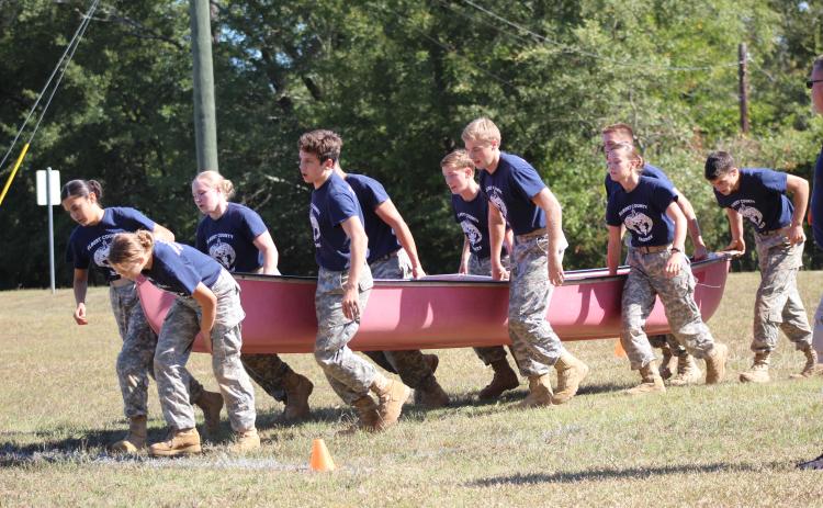 Elbert County JROTC Mix Team members (L-R) Marilyn Flores, Makayla Ingle, Haylee Marunich, Mathew Fernandez, Dean Blanchard, Justin Bastyr, Brandon Nestor, Maelynn Ruff, Gabriel Ruff and Thomas Vaughn race through the physical team test event while holding a canoe during a home Raider meet Oct. 12. (Photo special to The Star).