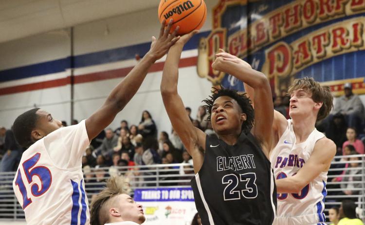 Blue Devil freshman Christian Harris (center) shoot between Patriot defenders during Elbert County’s 76-37 region win at Oglethorpe County Jan. 17 in Lexington.(Photo by Dan Giles)