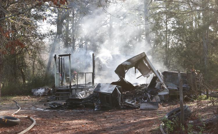 Remnants of a structure fire at 1531 Dunn-Worley Road smolder as Elbert County firemen walk around the structure on Thursday, March 12. The fire, listed as a “structure fire/arson” in the incident report from the Elbert County Sheriff’s Office, occurred at 9:22 a.m.  The Georgia Fire Marshal’s office said an Elbert County woman has been charged with causing the fire. (Photo by Scoggins).
