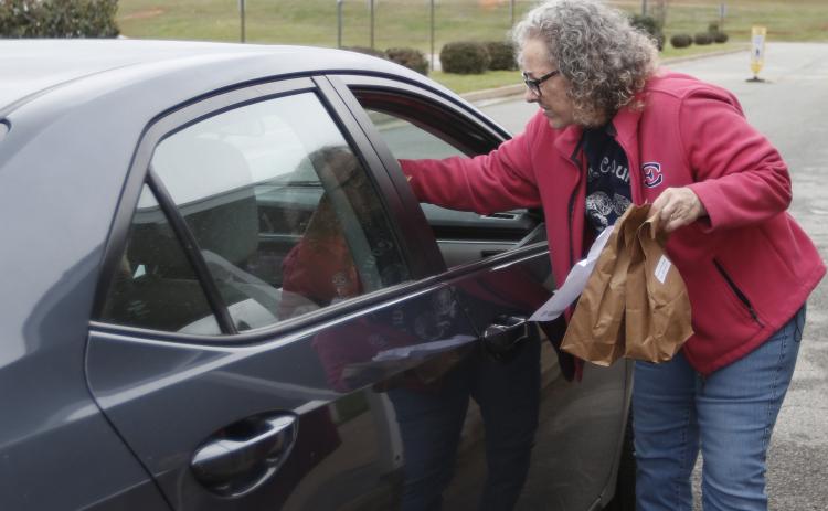 Barbara Bennett assists in distributing lunches called ‘Grab and Go’ at Elbert County Middle School. All schools are preparing student meals for students despite school closures in Elbert County. (Photo by Scoggins)