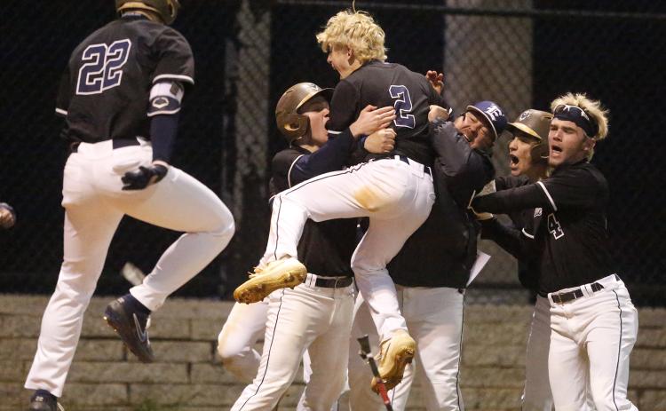 Diamond Devils (L-R) Carter Dye, Skylar Bray, Carson Adams, coach Lance Ingram, Jordan Mills and Kyle Moon react to Adams scoring the game-winning run in Elbert County’s 8-7 win over Rabun County Feb. 28 on Devils Field. (Photo by Cary Best)