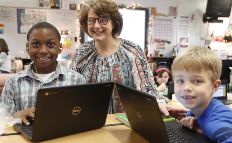 Elbert County Elementary School Principal Stephanie Wiles checks out the work of students Ethan Watkins (left) and Levi Wiles (right) on computers at the school recently. (Photo by Scoggins)