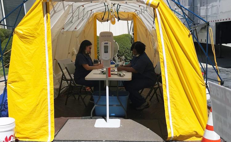 Andrea Webb (left) and Margie Rucker are screening all persons entering Elbert Memorial Hospital in a tent outside of the hospital’s emergency room. (Photo by Jones)