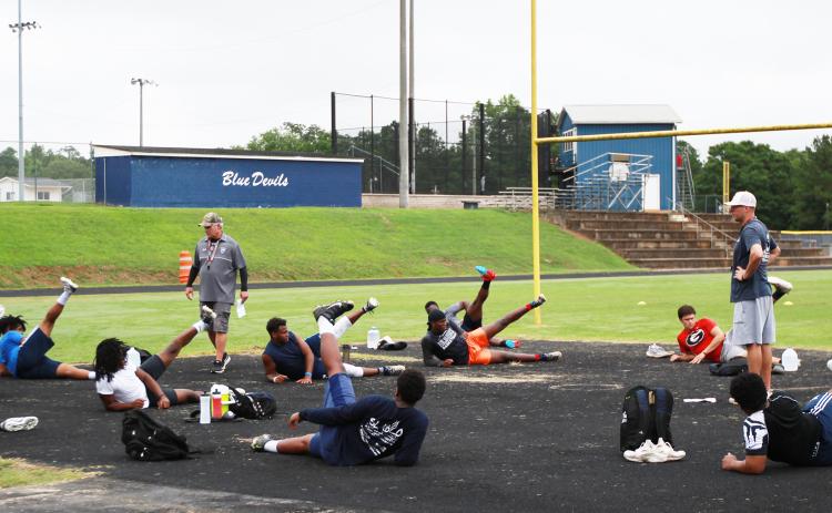 Elbert County football coaches Tommy Gilstrap (left) and Reuben Haynes (right) work with Blue Devil football players during voluntary player workouts Monday morning. Two groups of players worked out on Monday morning under guidelines issued by the state and the Center for Disease Control. (Photo by Scoggins)