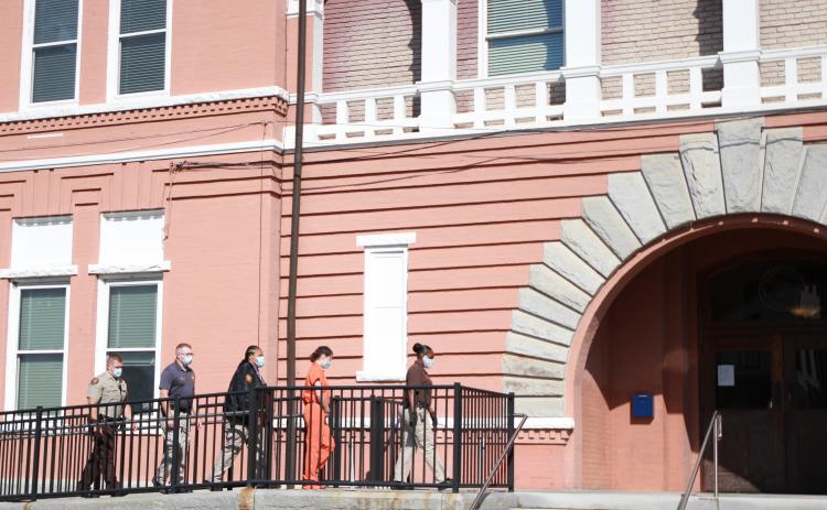 Carrie Jill Peppers is escorted by four detention center officers to the front of the Elbert County courthouse Monday morning to attend her first appearance hearing after being arrested and charged with murder in the second degree and cruelty to children in the second degree.