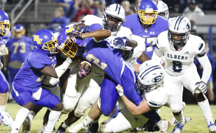 Elbert County’s defense hangs on to Washington-Wilkes running back Quinshawn Hearst Friday night in Washington. The Tigers took control of Friday’s contest early then coasted to a 42-7 victory over the Blue Devils. (Photo by Scoggins)