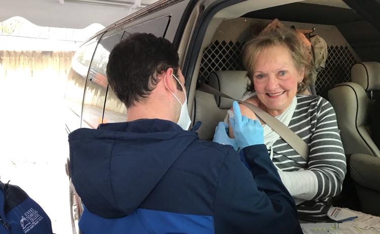 Kathy Pfaender of Hartwell gets a vaccine from Athens Tech nursing student Alex Higgins at EMH’s drive-through Monday morning. (Photo by Jones)