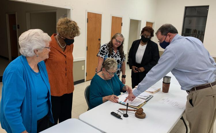City Attorney Richard Campbell (far right) shows Mayor Roberta Rice (middle) where to sign to officially enter into an agreement with theGeorgia Environmental Finance Authority for a $1 million loan from the Drinking Water State Revolving Fund that will improve the city’s water system and could be see forgiveness of over half of the loan. Watching Rice sign the agreement were (L-R) council members Betty Jo Maxwell, Mary Clark, city clerk Cynthia Johansen and Henrietta Williams. (Photo by Scoggins)