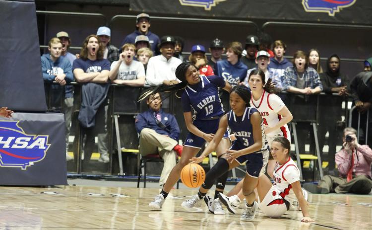 Elbert County Lady Devil fans in the background were shocked after junior guard Aaniyah Allen makes a steal and leaves a Rabun County Ladycat on the floor of the Macon Coliseum during Thurday’s state championship game. The Lady Devils defeated Region 8AA foe Rabun County 52-44 to bring home the program’s first state championship title. (Photo by Scoggins)