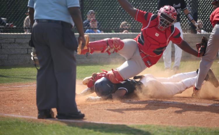 Therell’s catcher falls on Diamond Devil Trustin Allen after he slid safely into home plate during the first round of the GHSA state playoffs at Diamond Devil field Friday, April 29. (Photo by Scoggins)