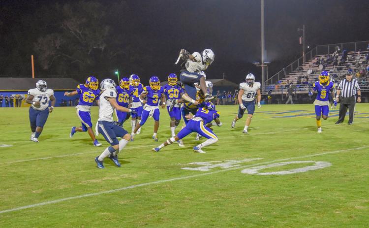 Senior Quan Moss hurdles over a Washington-Wilkes Tiger during Friday’s 32-20 win over the No. 5-ranked Washington-Wilkes High School in Washington.