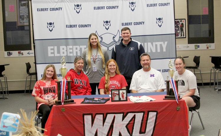 Lady Devil softball player Ava Lunsford signed to continue her softball career at Western Kentucky University Friday, Nov. 11 at Elbert County Comprehensive High School. Pictured during the signing ceremony are (front row, L-R) sister Audrey Lunsford, mom Karol Lunsford, Lunsford, dad Mike Lunsford and sister Elle Luns-ford; (back row, L-R) Coach Bria Bush and Head Coach Drew Greer. (Photo by Wells)