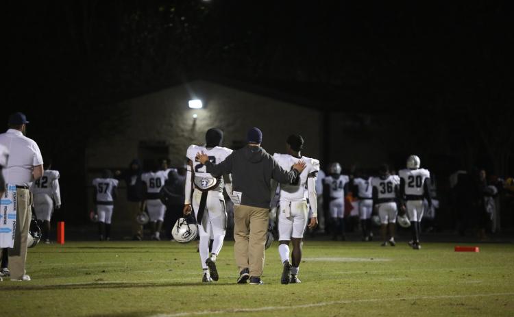 Assistant Coach Mike Williams walks off Prince Avenue’s field with sophomores Malik Hill (left) and Jermaine Sims (right) after the Devils’ 48-14 seasoning-ending loss Nov. 18.