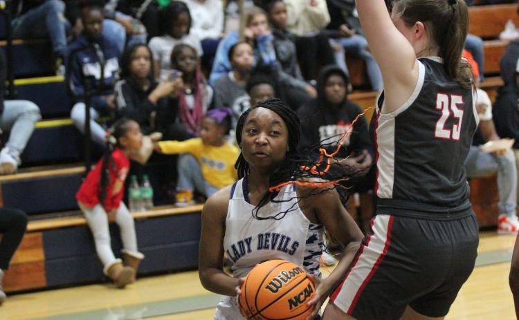 Junior Aameriah Allen dives under a Madison County defender on her way to the basket during the win over Madison County Dec. 9. (Photo by Wells)