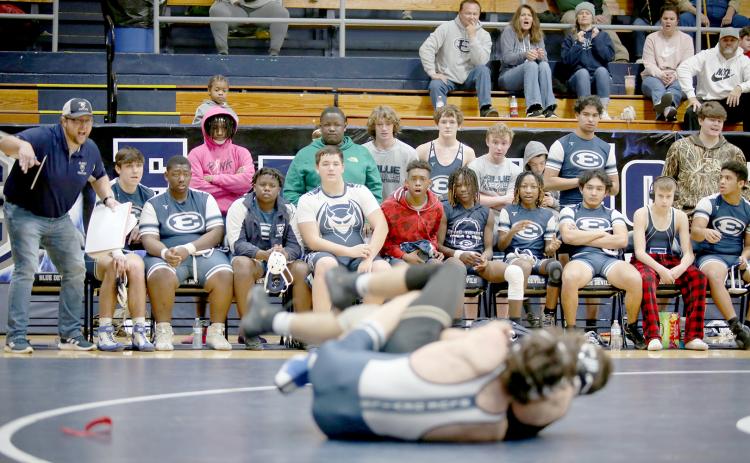 Mat Devils Head Coach Shane Anderson (far left) coaches Carter Fleming during a match against Commerce High School in the area duals Jan. 7 in the Inferno. Anderson hit his 200th dual win as a coach in December. (File photo by Scoggins)