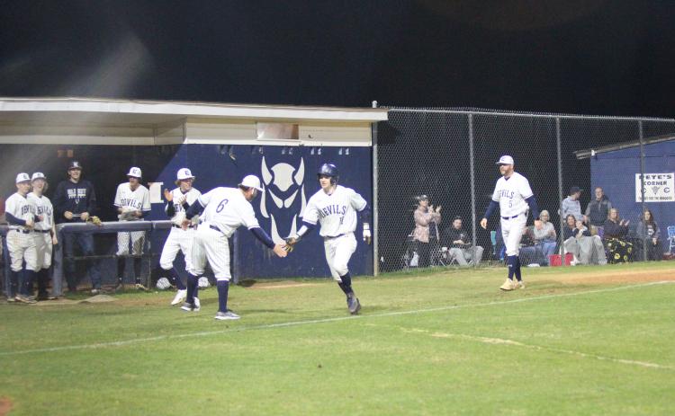 Head Coach Lance Ingram (left) congratulates Skylar Bray (right) as he runs home after knocking out a grand slam during the Devils’ 9-4 win over Hart County Feb. 8 at Diamond Devil field. (Photo by Wells)