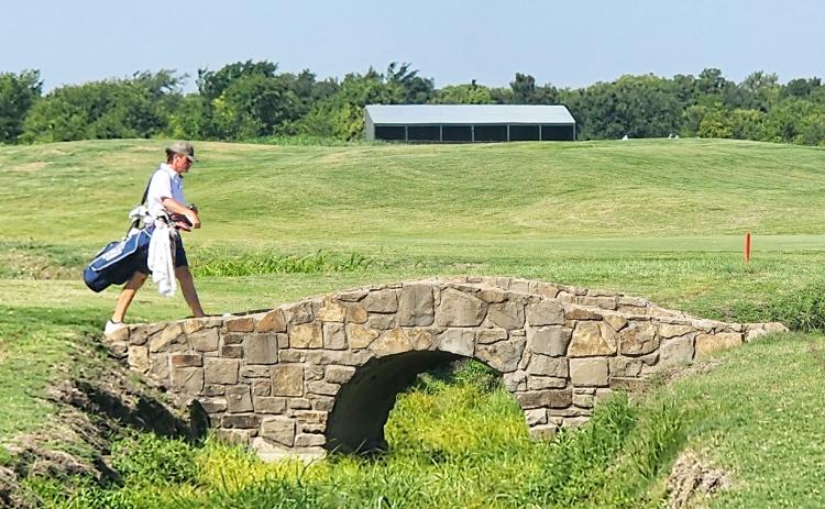 Elbert County Blue Devil senior Brady Starrett walks across a bridge at the Tribute Links Course in Frisco, Texas during the 2023 Boys High School Golf Invitational. The bridge is made to look identical to the famous No. 18 hole of the historic St. Andrews Links.