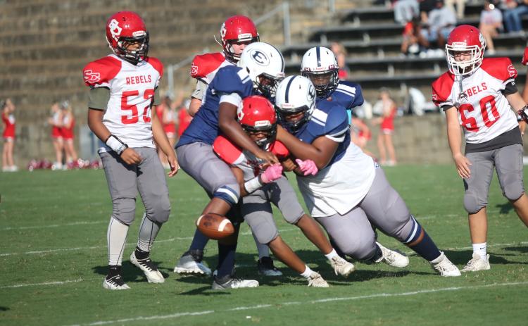 A pair of Rams tackle a Stephens County player as the ball pops loose for a fumble in Elbert’s 22-0 loss to the Rebels Aug. 31. (Photo by Wells)
