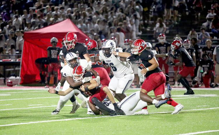 No. 54 Seneca Turner and No. 42 D.J. Fortson wrap up the Harlem quarterback in the backfield late in the game. (Photo by Wells)