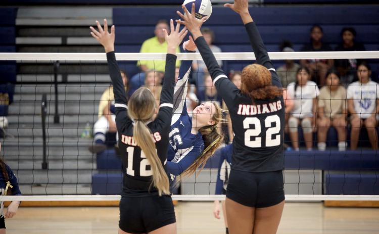Elbert County Volley Devil Johna Johnson hits the ball over the net as two Stephens County players try to block her shot. (Photo by Wells)