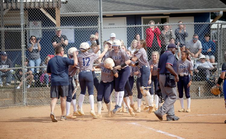 The Lady Devils swarm Ky Dubose at the plate after she hit a home run in Elbert’s game against Trion Oct. 19.  (Photo by Wells)