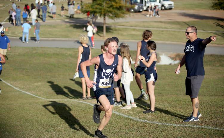 Head Coach Kyle Ashworth points up the track as Ezra Adamson runs by during the Region 8A Division 1 championship meet. (Photo by Wells)