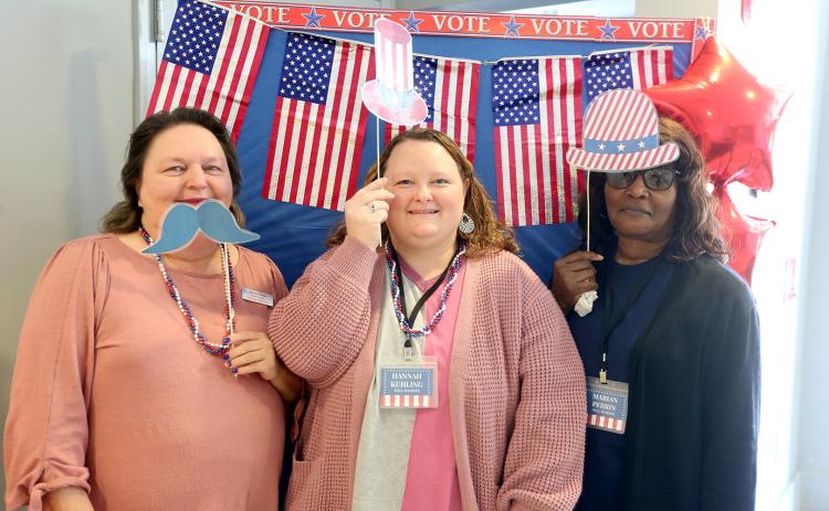 Elections Supervisor Melissa Shead (left) and poll workers (L-R) Hannah Kuhling and Marian Perrin pose for a picture in the foyer of the Historic Rock Gym. A "selfie station" has been set up for voters to take a picture with props after casting their vote in the Presidential Preference Primary. Photos can be shared with the Board of Elections and Registration Office by emailing voteec@elbertga.us for a chance to be featured on the office's Facebook page. (Photo by Scoggins)
