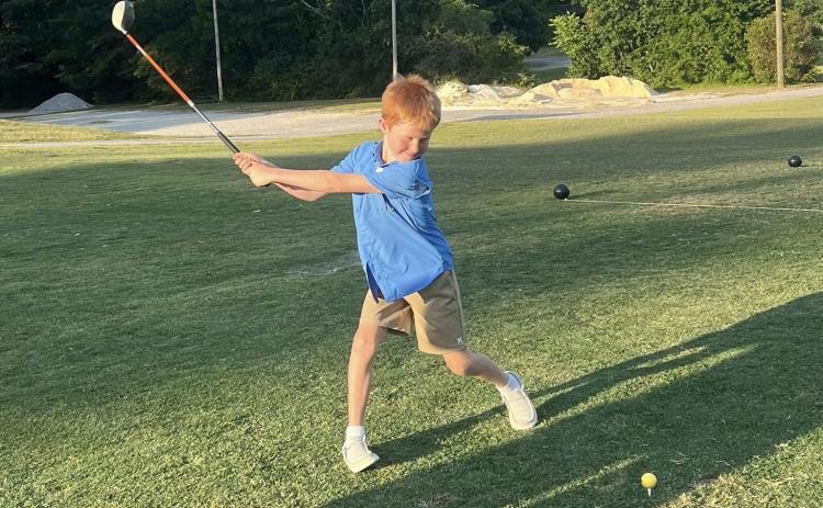 Youth golfer Benson Holland takes a swing at the ball during the Elbert County Future Blue Devil Golf Camp held June 17, June 18 and June 20. (Photo courtesy of Larry Kesler)