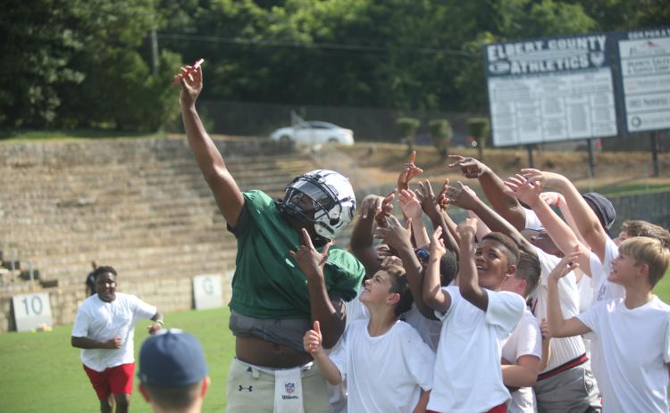 Left, Quarterback Jayvyn Hickman (far left) takes a selfie with a host of young Devil fans using one of the fans’ phones during last year’s Community Kickoff. (File photo by Wells)