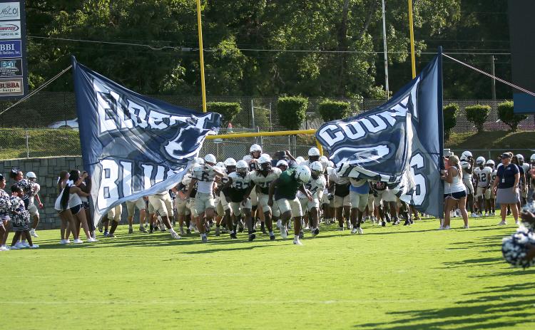 Charging through the first run-through sign of the season, the ECCHS Blue Devils take the field at the Friday Night Lights Community Kickoff Friday, Aug. 9 in the Granite Bowl. The Devils ran various plays and drills and had a practice scrimmage during the event while fans watched from the stands.  Also on hand this season's new cheerleading squads, band and auxiliary members and youth league football and cheerleading squads. (Photo by Weeks)