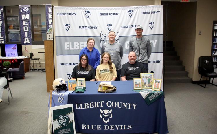 Lady Devil softball player Emily Booth signed her letter of intent to join former Elbert County softball Head Coach Drew Greer and play college softball at Piedmont University Dec. 16. Pictured with Booth during the signing ceremony are (front row, L-R) Bethany Booth, Emily Booth, Greg Booth and (back row, L-R) Faith Burgamy, Josh Jones and Bryce Bowen.