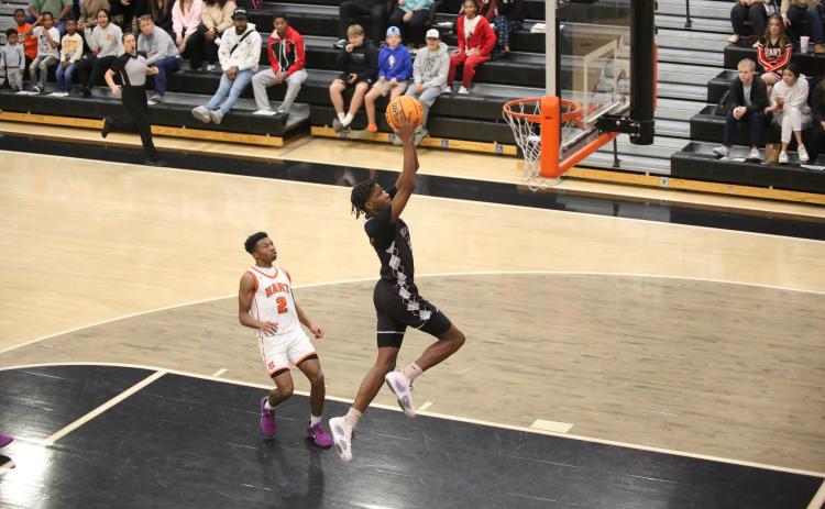 A.J. Brown soars through the air to punctuate a fast-break chance with a slam dunk during Elbert’s loss to Hart County Dec. 28. (Photo by Wells)