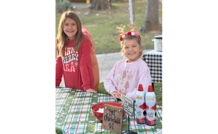 Brylee (L) and Bria (R) Dickerson set up a hot chocolate stand in their neighborhood Dec. 7 and raised over $1,000 for a needy family. (Photo submitted by Brooke Dickerson)