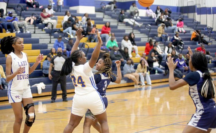 Zoe Evans (left) passes behind her back to Aaliyah Allen (right) during Elbert’s win over Warren County Jan. 18. (Photo by Wells)
