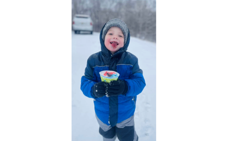 Chandler Truitt enjoys a homemade snow cone with freshly-fallen snow while playing on Springdale Drive during the Jan. 10 Snow Day. (Photo submitted by Kathy Jossey)