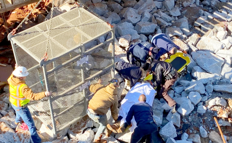EMS team members move the injured worker onto the gurney prior to loading him into the quarry box to be lifted to safety. (Photo courtesy of Elbert County Emergency Services)