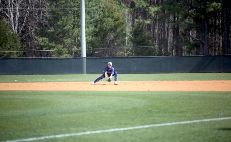 Rylan Brown fields a ground ball before throwing over to first base for an out in the first game of Elbert’s doubleheader on the road against Athens Academy. (Photo by Wells)