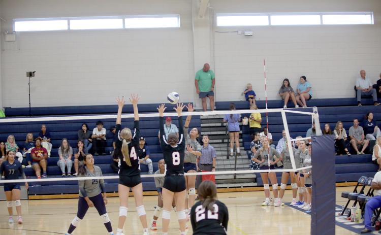 Alexa Vargas carefully tips the ball over the net above a pair of Rabun County opponents. (Photo by Bo Underwood)