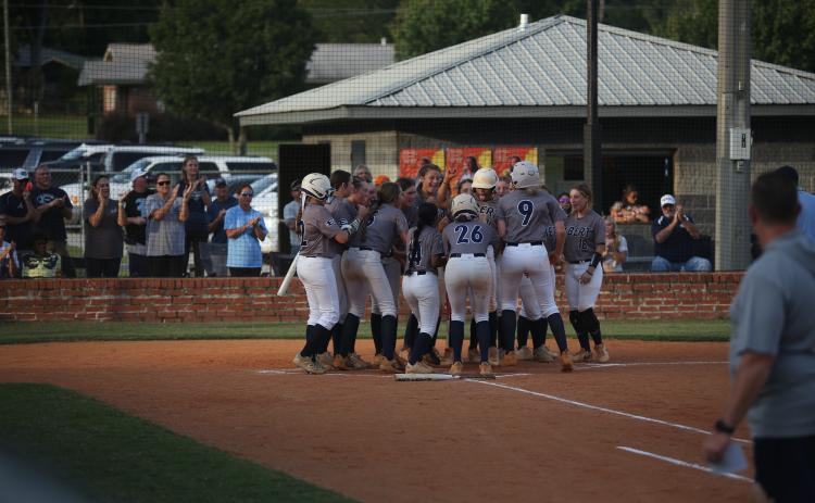 The Lady Devils softball team swarms Ky Dubose at home plate after she hit a home run in their rescheduled game against Hart County Aug. 27. (Photo by Bo Under