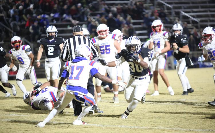 Petey Allen (30) stiff-arms a defender in Elbert’s 24-7 playoff win over Oglethorpe on Nov. 14. (Photo by Bo Underwood)