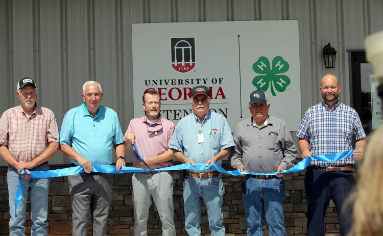 (L-R) Commissioners Mike Scoggins, David Hunt, commission chair Lee Vaughn, Commissioners Casey Freeman, Chris Alexander and county manager Allen Hulme prepare to cut the ribbon during a ceremony celebrating the grand opening of the county's new 4-H facility. (Photo by Bo Underwood)