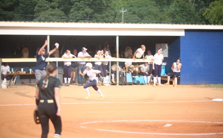 Bellamy Nash runs home as Bryce Bowen holds the other runner. (Photo by Bo Underwood)