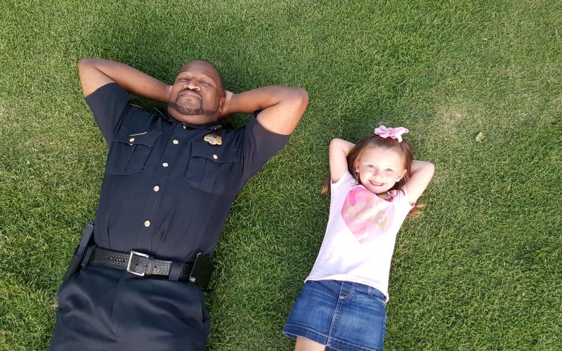 aking it easy is Elberton Police Capt. Darin Rucker (left) and a friend, Aspen Wright, who are relaxing after an event Rucker conducted as a part of the Elberton Police Department’s relationship-building efforts in the community.