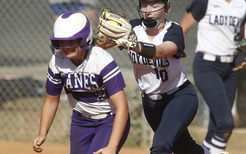 Lady Diamond Devil freshman shortstop Lilly Ray (right) tags out Lady Purple Hurricane Azure Guli during the first game of a region tournament doubleheader with Monticello Sept. 25 on King Field in Elberton. (Photo by Cary Best)