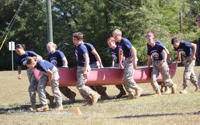 Elbert County JROTC Mix Team members (L-R) Marilyn Flores, Makayla Ingle, Haylee Marunich, Mathew Fernandez, Dean Blanchard, Justin Bastyr, Brandon Nestor, Maelynn Ruff, Gabriel Ruff and Thomas Vaughn race through the physical team test event while holding a canoe during a home Raider meet Oct. 12. (Photo special to The Star). 
