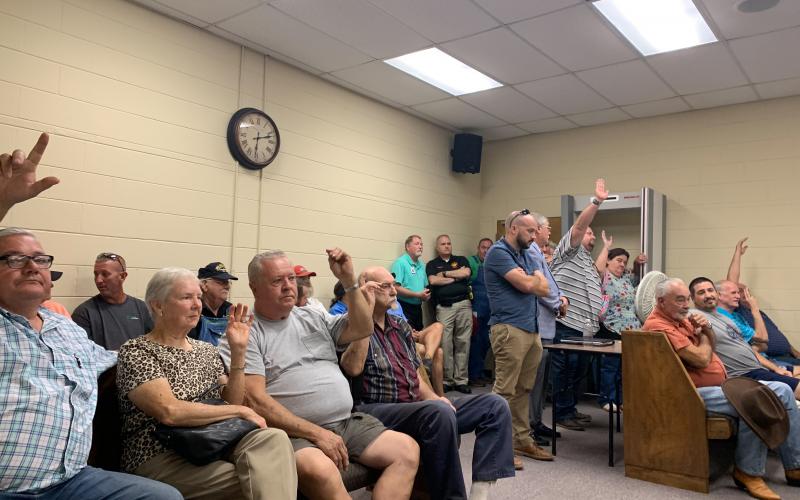 The crowd at the public hearing responds to Chairman Butch Smith's question regarding who was opposed to bringing in a solar energy facility. (Photo by Rose Scoggins)