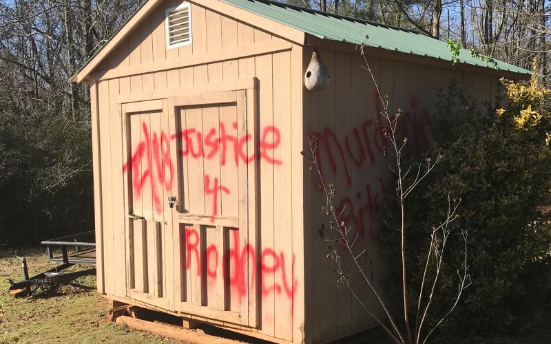 Messages left on an outbuilding – ‘2/18 Justice 4 Rodney’ and ‘Murdering b----’ may have tied Thursday’s explosion to the murder of an Anderson, South Carolina paramedic in which there has been no arrest. (Photo by Jones)